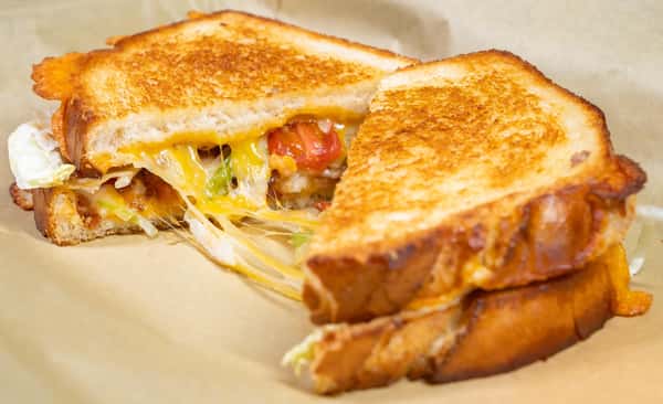 Grilled cheese sandwich stack with melted cheese and tomato