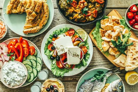 Mediterranean spread with grilled fish, fresh salad, flatbread, and assorted mezze dishes on a rustic table