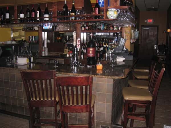 bar area with bottles displayed on the wall