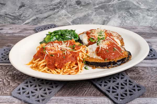Plate of spaghetti with marinara and eggplant parmesan, served with sautéed spinach and grated cheese