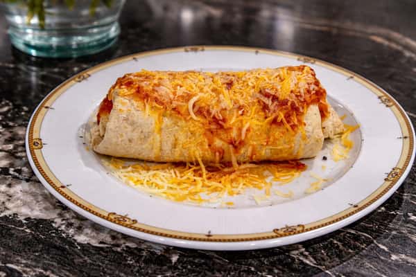 Grilled breakfast burrito smothered in melted cheese and savory sauce, served hot at Cinnamon Restaurant Café.