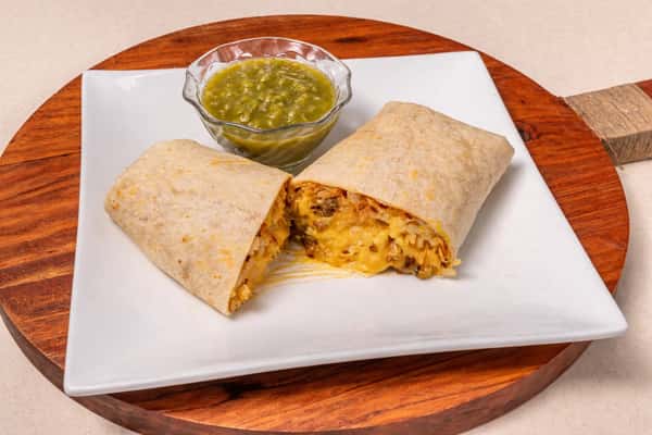Grilled breakfast burrito filled with eggs, cheese, and savory ingredients, served with green salsa.