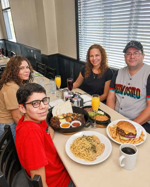Family enjoying breakfast together with pancakes, pasta, and classic café favorites at Cinnamon Restaurant Café.