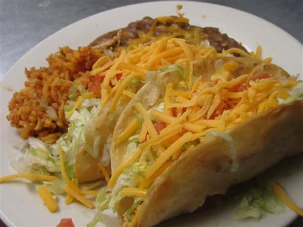tacos topped with cheese, lettuce, tomato