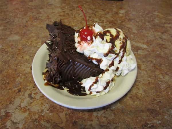 chocolate cake with ice cream and a cherry on top