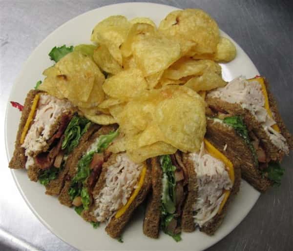 turkey sandwich cut in half with potato chips
