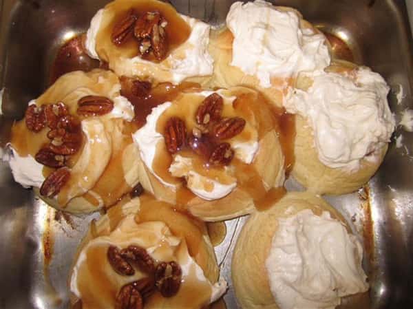 dessert tarts topped with syrup, pecans and whipped cream