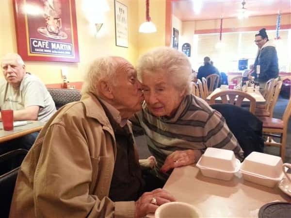 elderly man kissing elderly female