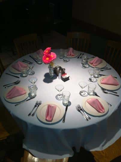 Big round table set with table sets and decorated with ink napkins and flowers