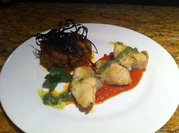 Monk fish special. We begin with Monk fish sauteed and plates over a red pepper sauce and topped with a basil pesto served with a side of sweet eggplant camponata.