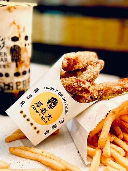 Crispy Taiwanese fried chicken from Chunky Boss with seasoned fries and a Tiger Sugar bubble tea in the background.