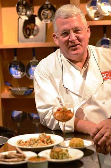 Chef standing beside dish