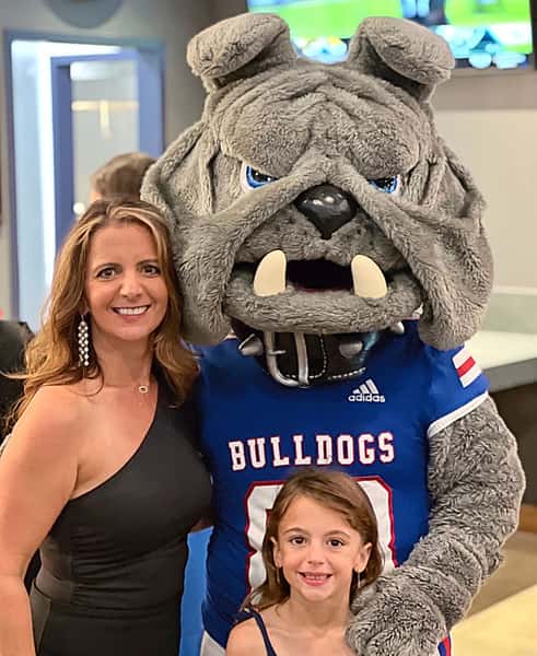 woman and child taking picture with bulldog mascot