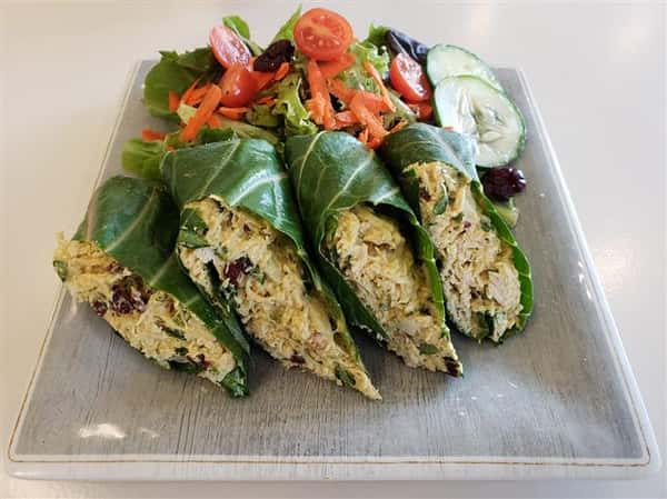 Lettuce wrapped chicken salad paired with a salad topped with shredded carrots and cucumbers.