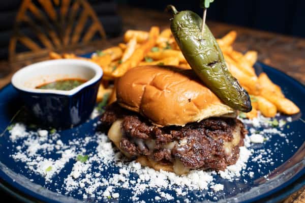 Birria Smash Burger is the one everyone talks about for a reason: your choice of slow roasted beef or goat birria stacked over two juicy Amercian Wagyu Smash Burger patties with onions, Mexican cheese blend, and chipotle mayo on a Martin's potato roll, served with consomme and Mexican cajun fries. One bite in, and it's easy to see why Birria Smash Burger is such a guest favorite. 🍔🔥 #TheVegasCantina #BirriaSmashBurger #GuestFavorite #BurgerLovers