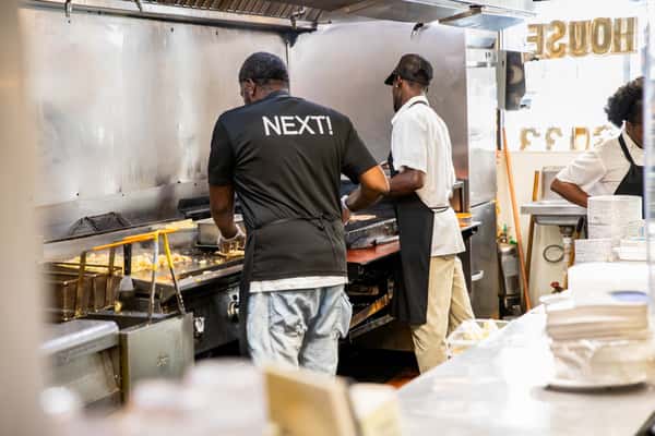 Kitchen staff working together behind the cafeteria counter.