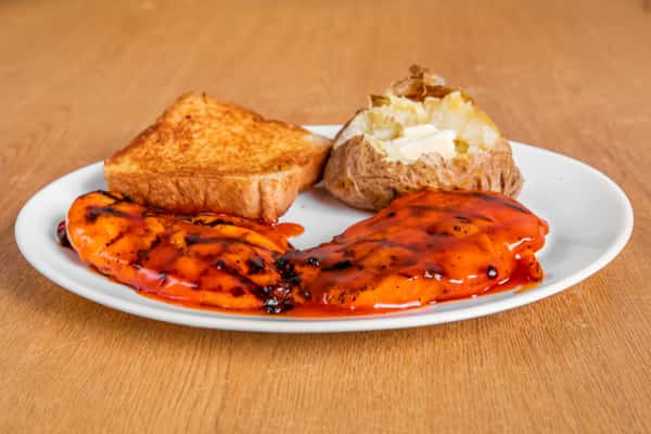 Grilled chicken fillets served with toast and a baked potato.