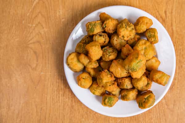 A plate of golden breaded okra, viewed from above.
