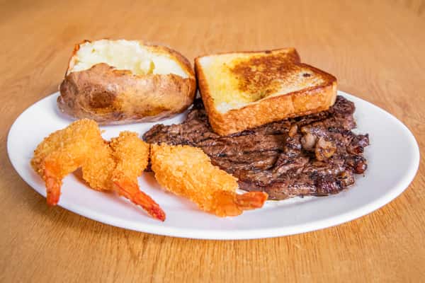 Grilled steak and breaded shrimp with toast and a baked potato, viewed from the side.
