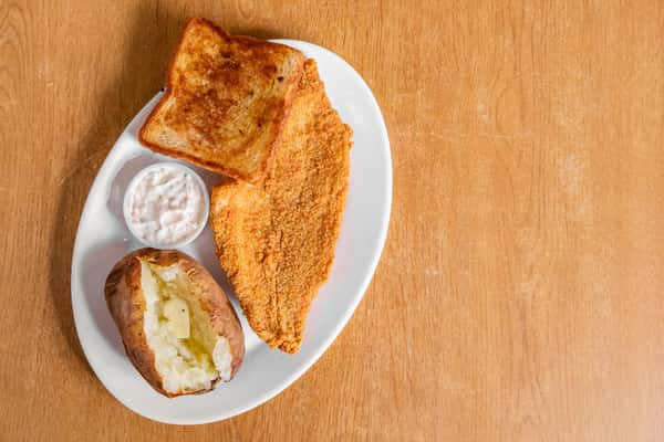 Breaded fish fillet with a baked potato, toast and sauce, viewed from above.