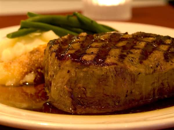 cooked steak on a plate with green beans