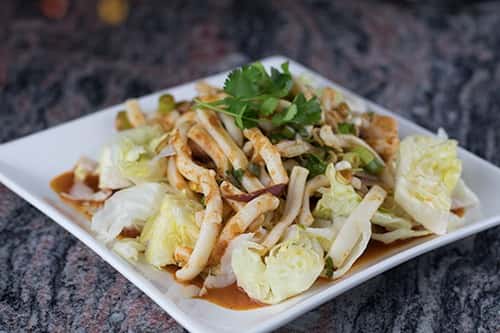 Squid lightly sautéed in lemon grass, mint and lime sauce, on top of a bed of lettuce.
