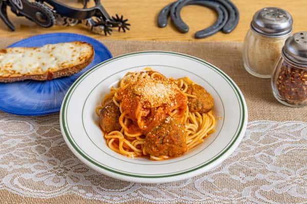 Classic spaghetti and meatballs smothered in marinara sauce and sprinkled with Parmesan cheese, served in a white ceramic bowl with a slice of toasted cheese bread and traditional Italian seasonings.