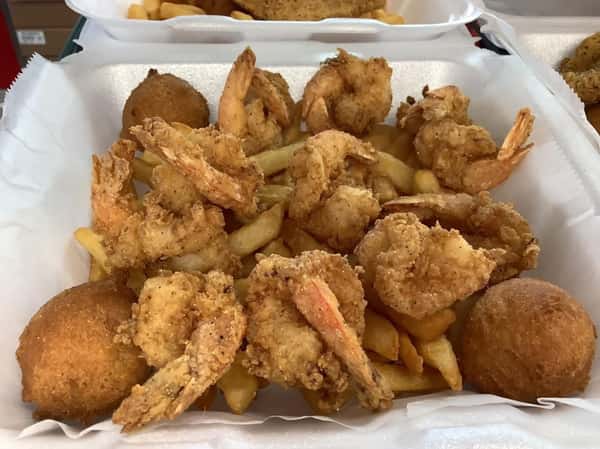 Golden fried shrimp, french fries, and hushpuppies in a white container from Seafood Shack & More.