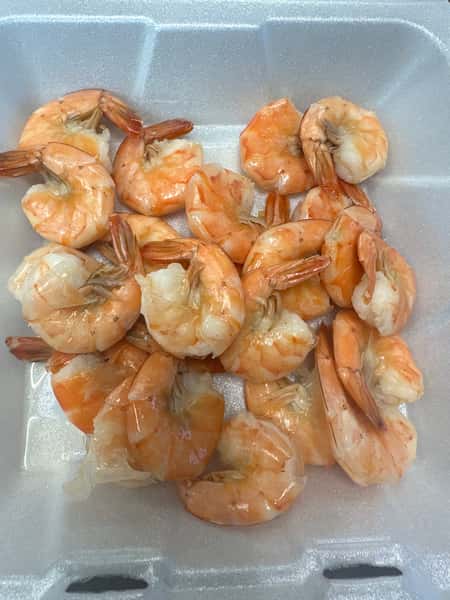 Plump cooked orange and pink shrimp in a white container from Seafood Shack & More.