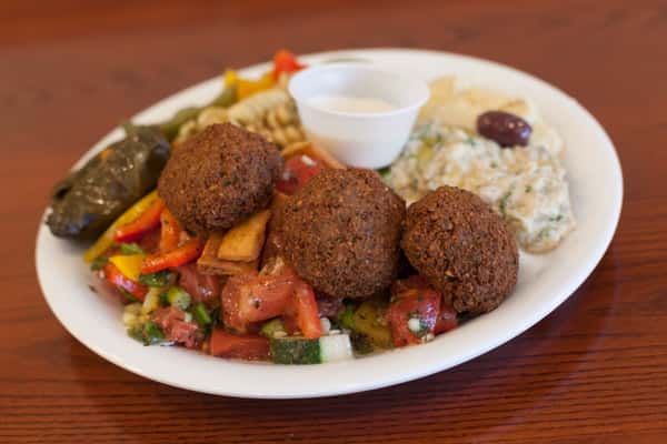 Fried meatballs, sauteed peppers and onions, and grape leaves