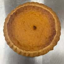 Freshly baked classic pumpkin pie with a golden-brown crust and smooth spiced filling, presented in a traditional pie shell, highlighting a homemade seasonal dessert ideal for fall menus and holiday gatherings.