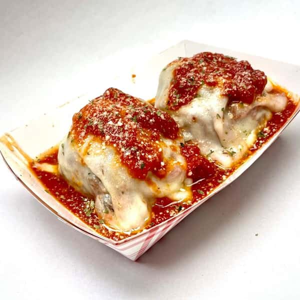 Two oversized meatballs with a bed of savory marinara and topped with melted provolone and parmesan.