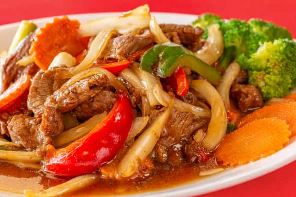 Stir-fried beef with bell peppers, onions, mushrooms, and broccoli in savory brown sauce, served with carrot slices.