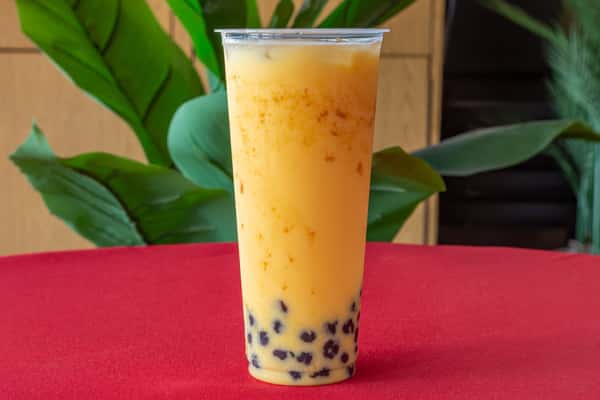 Thai iced tea with boba pearls in a clear cup, showcasing the drink's rich orange hue and creamy texture—popular Southeast Asian bubble tea with a sweet, spiced flavor profile