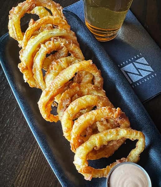 onion rings with a side of dipping sauce