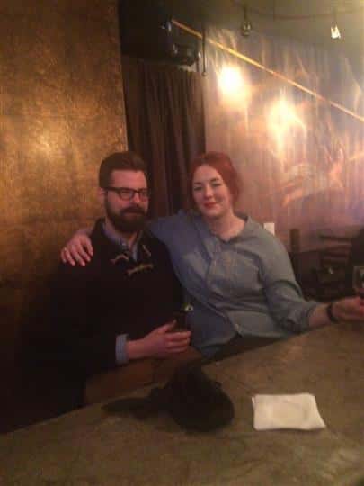 two friends smiling together at a bar