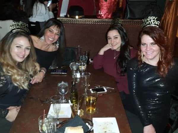 four customers smiling at a table wearing new year attire