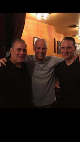 three guys posing together and smiling
