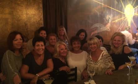 a group of women smiling together at the bar