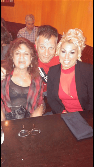 three customers smiling at their table