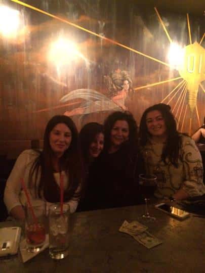 four women smiling together at the bar