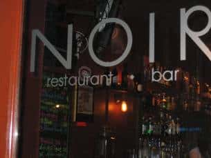 glass door that says "Noir restaurant and bar"