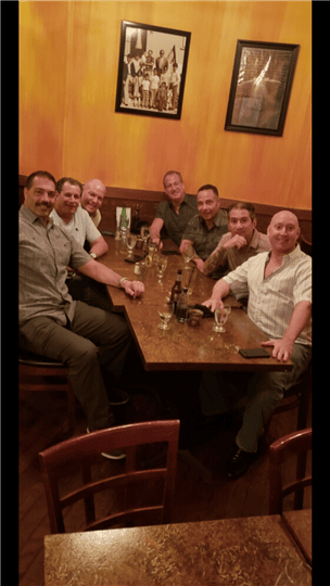 a group of 7 people smiling at their table