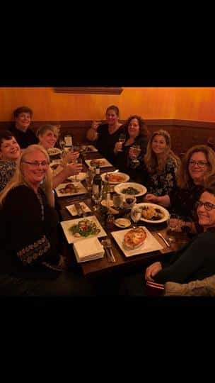 a group of happy customers with their plates of food at their table