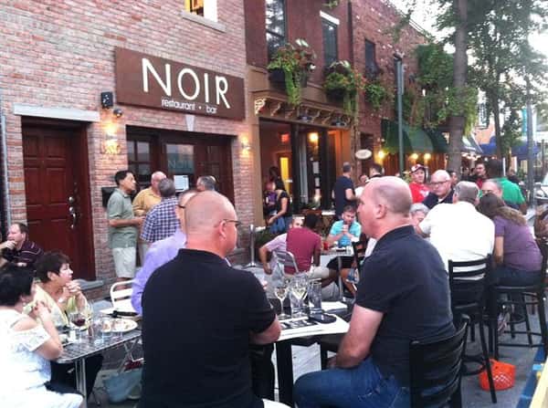 crowded outdoor seating area in front of noir