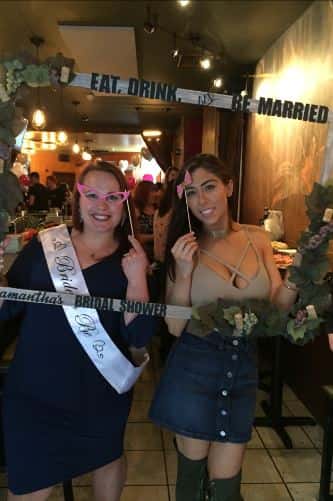 two women posing with bridal shower attire
