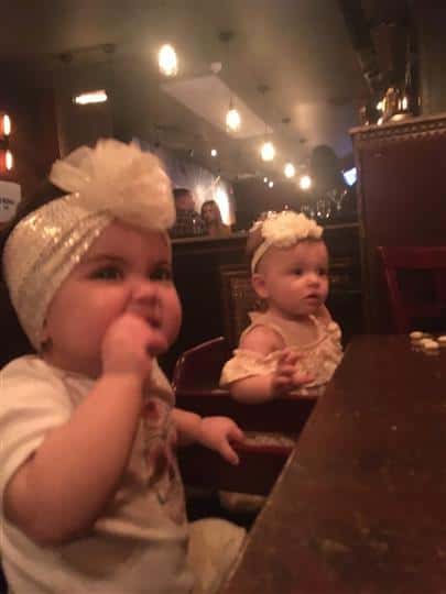 two babies in their high chairs eating
