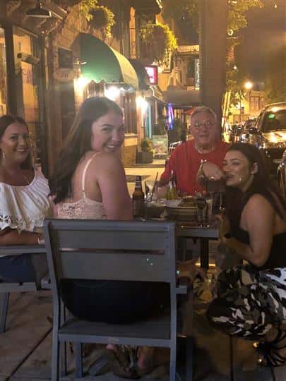 four customers eating in the outdoor seating area at night