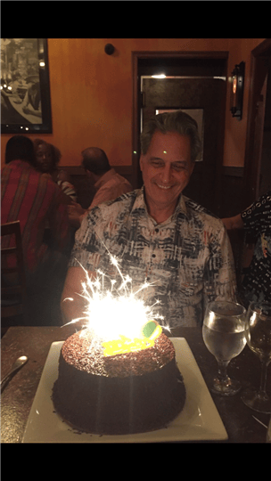 a happy customer with a sparkler on a cake