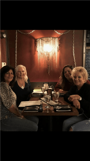 four women smiling at their table